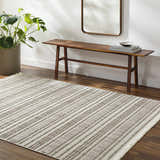 Entryway with Avari Area Rug in beige stripes, wood bench, mirror, and potted plant. Roomscene-Rectangle
