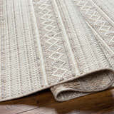 Close-up of the Dagan Area Rug showing its beige, gray, and cream textured weave and geometric pattern. Fold