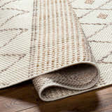Close-up of the Finch Area Rug showing beige and brown geometric pattern and textured machine woven construction. Fold