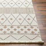 Close up of the beige and brown geometric pattern on the Finch Area Rug, with fringe detail. Front