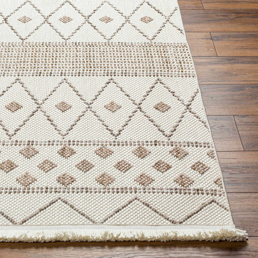 Close up of the beige and brown geometric pattern on the Finch Area Rug, with fringe detail. Front