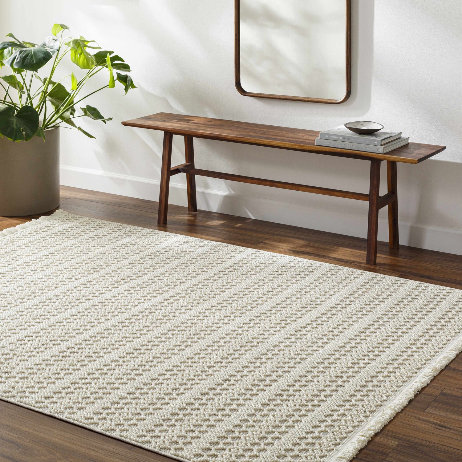 Entryway with a light gray Hamal Area Rug, wood bench, mirror, and monstera plant. Roomscene-Rectangle