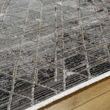 Close up of Luol Gray Area Rug showing its charcoal, gray, and natural geometric design and soft texture. Texture