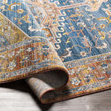 Close-up of the Solana Blue Medallion Area Carpet showing its bohemian pattern, blue, orange, and mustard colors. Fold