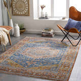 Living room scene with a Solana Blue Medallion Area Carpet, leather chair, and bohemian decor. The rug adds warmth and style. Roomscene-Rectangle