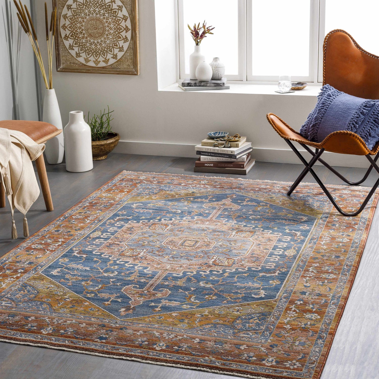 Living room scene with a Solana Blue Medallion Area Carpet, leather chair, and bohemian decor. The rug adds warmth and style. Roomscene-Rectangle