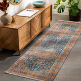 Hallway scene with a Solana Blue Medallion Area Carpet, wood console table, plants, and gray wood floors. Roomscene-Runner