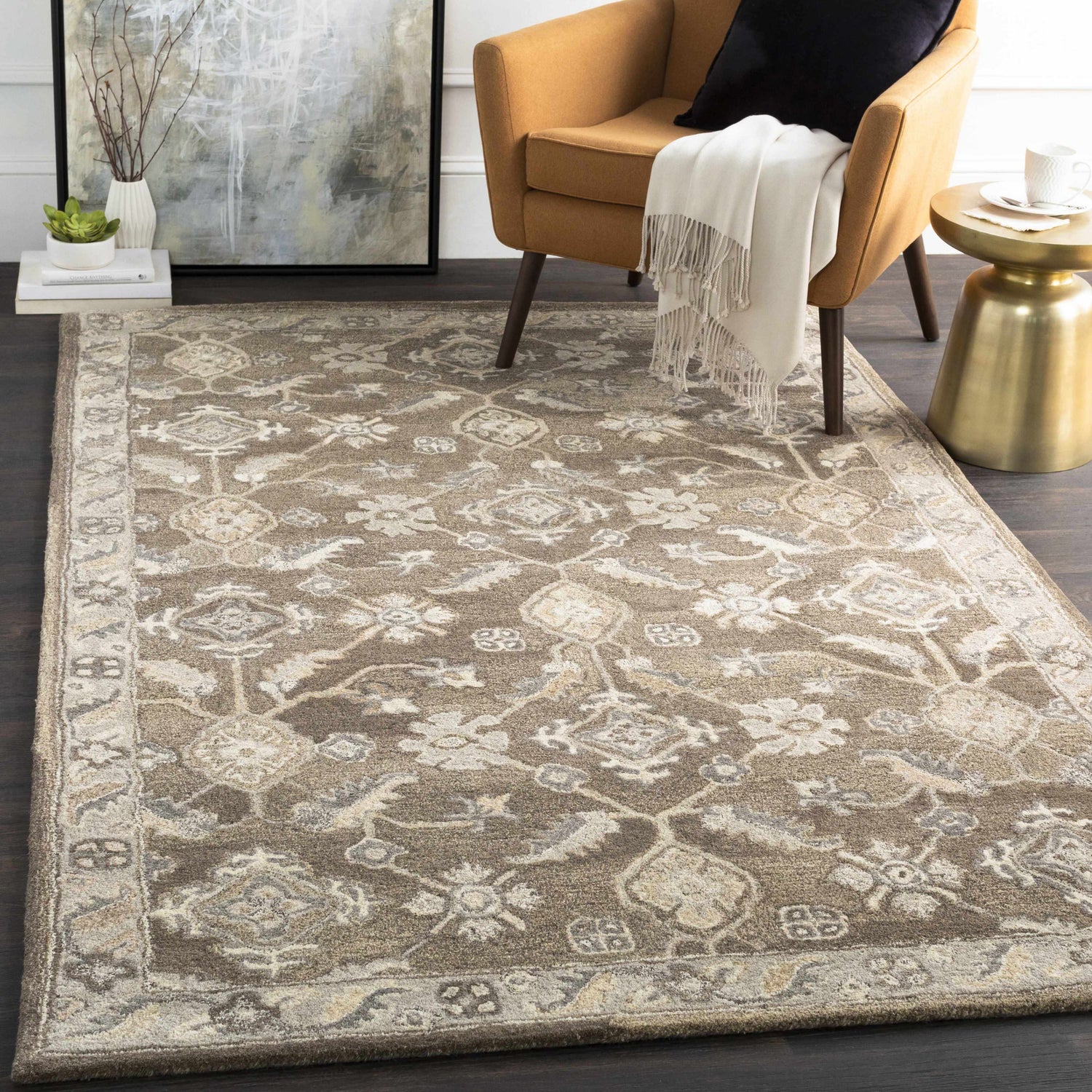 Living room scene with a brown Solen Area Rug, tan chair, gold side table, and dark wood floors. Roomscene-Rectangle