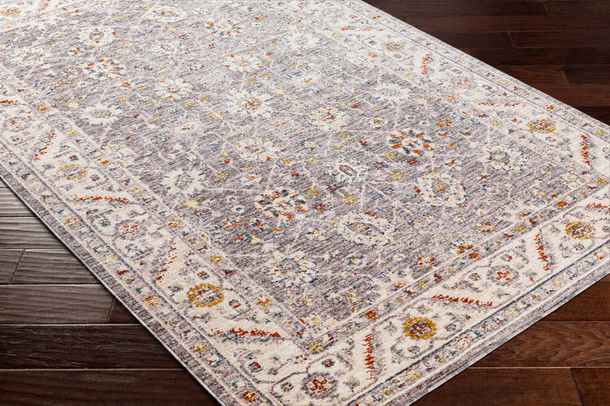 Close-up of the Sosi Area Carpet in dark beige, garnet, and gray on a dark wood floor. Traditional, farmhouse style. Corner