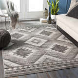 Living room scene with a gray and white Spade Area Rug, sofa, chair, and dark wood floors. Roomscene-Rectangle