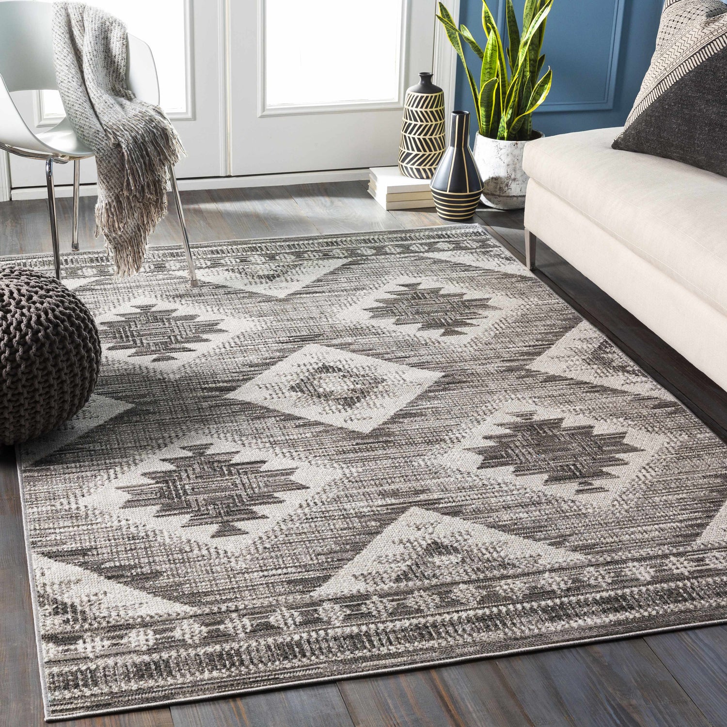 Living room scene with a gray and white Spade Area Rug, sofa, chair, and dark wood floors. Roomscene-Rectangle