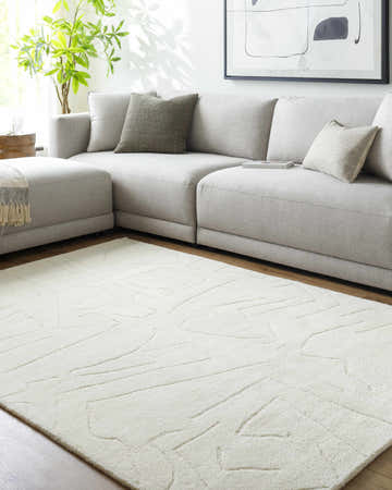 Living room scene with a light gray sectional sofa and the ivory Mony Area Rug. Roomscene-Rectangle