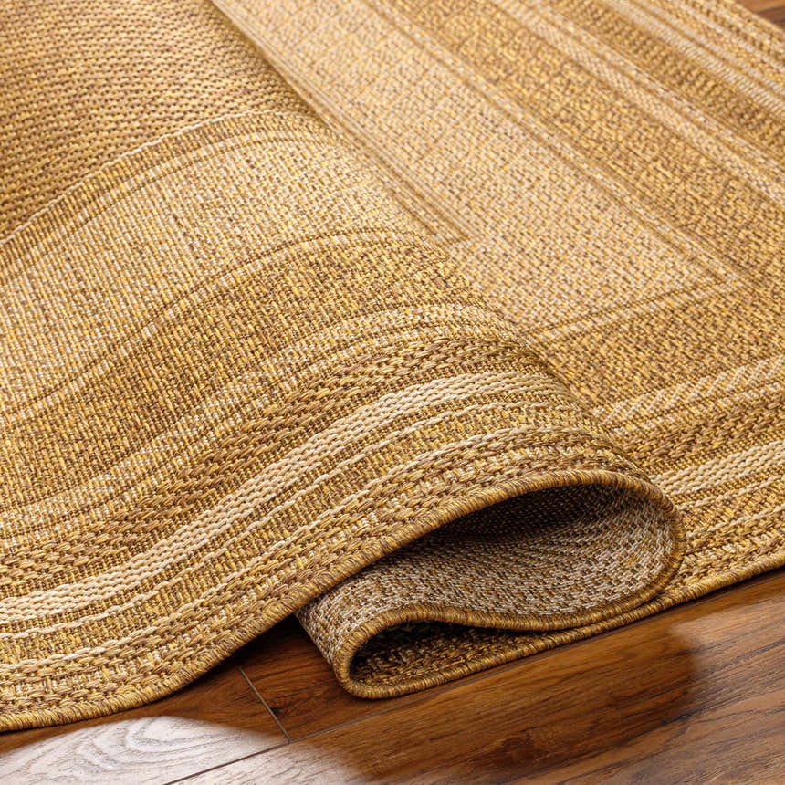 Close-up of the Chael Flatweave Faux Jute Rug showing beige, brown, and tan woven texture and rolled edge detail. Fold
