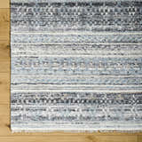 Close-up of the Blue Adda Area Rug showing its black, blue, and off-white Scandinavian-inspired pattern and hand-knotted texture. Corner