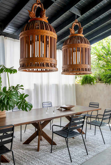 Dining room scene with a gray Kazi Area Rug under a wood table and black chairs, with decorative wood lamps. Roomscene-Rectangle