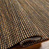 Close up of the hand woven Riki Black Area Rug showing jute texture and striped design. Fold