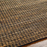 Close-up of the hand woven Riki Black Area Rug showing its jute texture and contemporary design. Texture