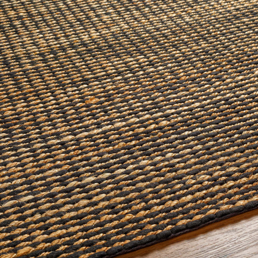 Close-up of the hand woven Riki Black Area Rug showing its jute texture and contemporary design. Texture