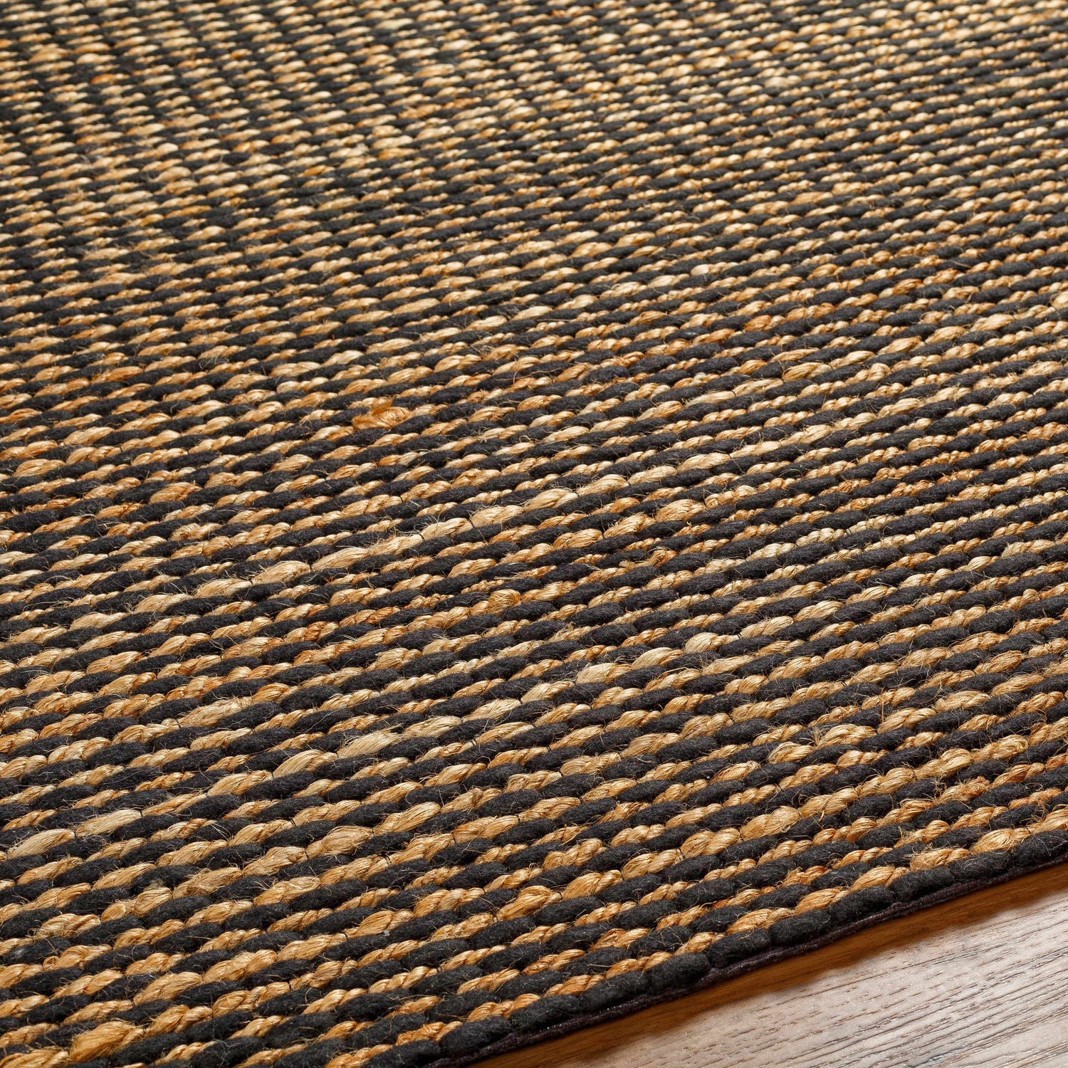 Close-up of the hand woven Riki Black Area Rug showing its jute texture and contemporary design. Texture