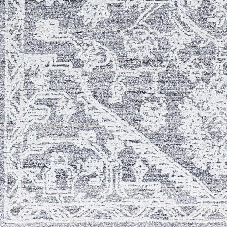 Close-up of Blue Derya Area Rug, showing traditional white floral pattern on gray recycled PET yarn. Hand-tufted texture. Swatch
