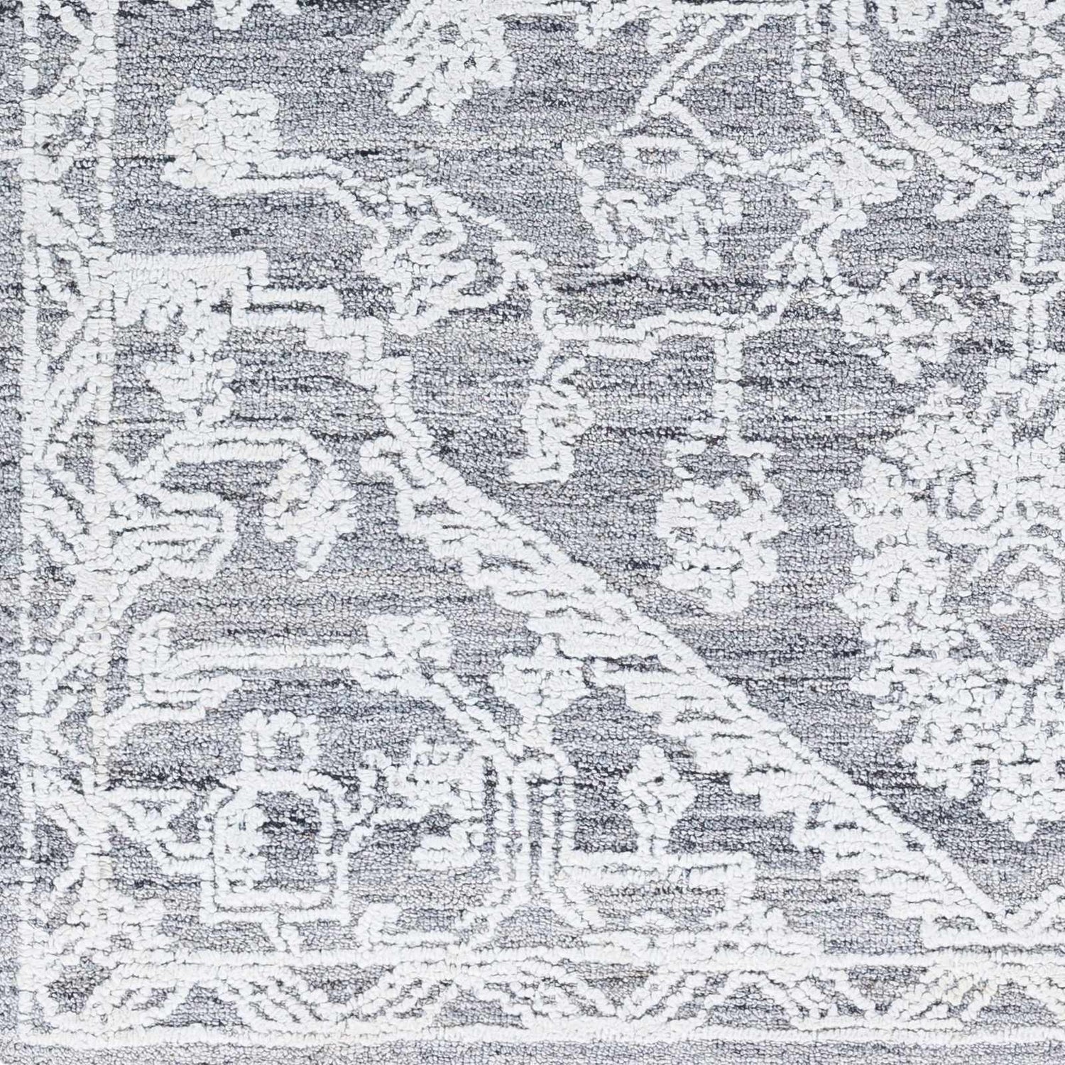 Close-up of Blue Derya Area Rug, showing traditional white floral pattern on gray recycled PET yarn. Hand-tufted texture. Swatch