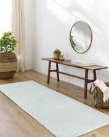 Entryway with wood floors and Isako Seafoam Solid Washable Area Rug runner, bench, mirror, and plants. Roomscene-Runner