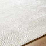 Close-up of the light silver Nazih Area Rug showing its hand-tufted texture and subtle off-white pattern. Texture