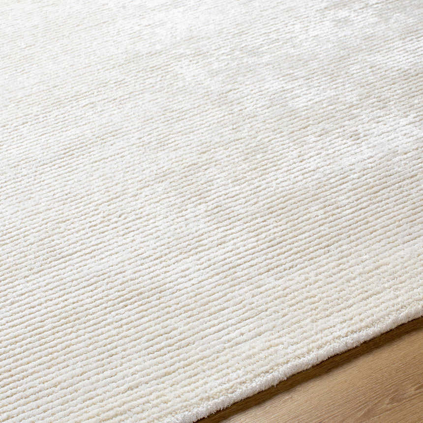 Close-up of the light silver Nazih Area Rug showing its hand-tufted texture and subtle off-white pattern. Texture