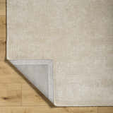 Close-up of the Ash Pirro Premium Wool Blend Rug showing its texture and backing on a wood floor. Fold