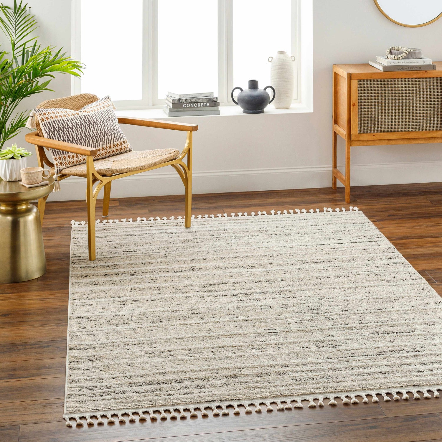 Living room scene with Miyu Taupe Area Rug, wood floors, chair, and cabinet in natural light. Contemporary style. Roomscene-Rectangle