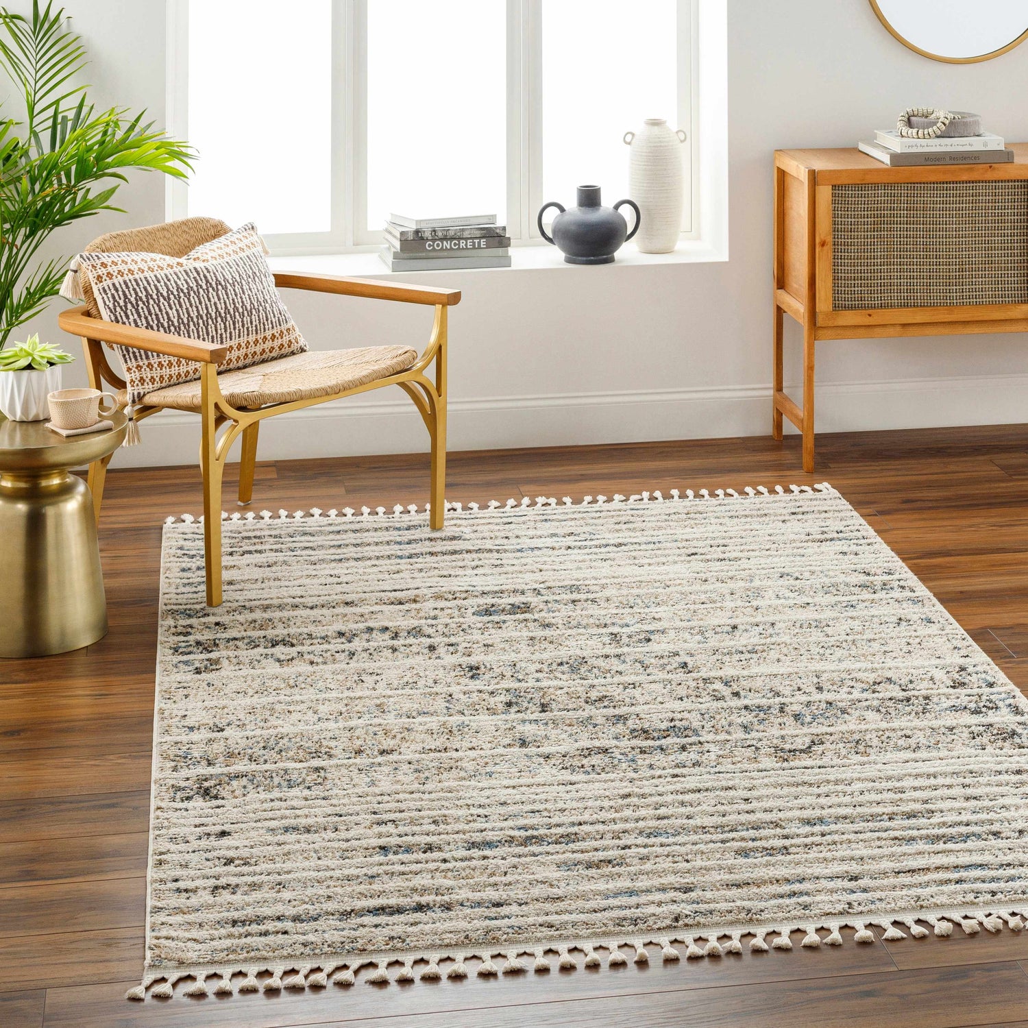 Living room scene with a Miyu Brown Area Rug, chair, side table, and wood cabinet. The rug has beige, brown, and blue tones. Roomscene-Rectangle