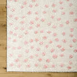 Close-up of the Bernt Beige Area Rug, a soft, textured rug with pale pink tufted dots on a beige background. Corner