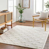 Living room scene with a bone Satu Cream Area Rug, wood console table, and gold accent chair. Roomscene-Rectangle