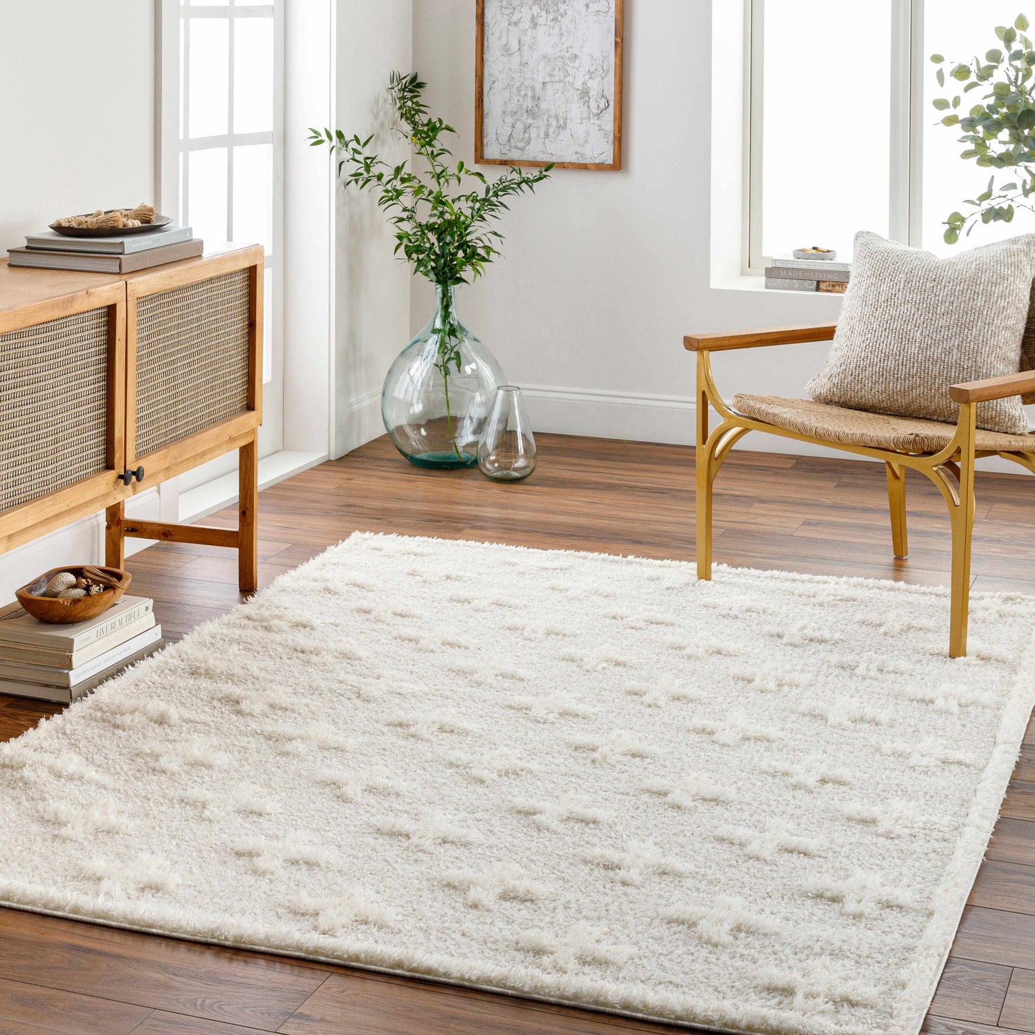 Living room scene with a bone Satu Cream Area Rug, wood console table, and gold accent chair. Roomscene-Rectangle