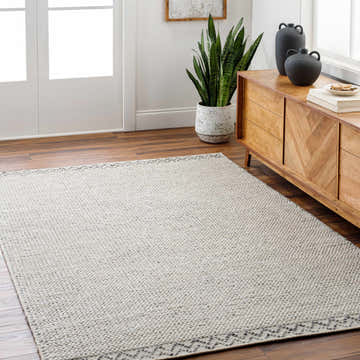 Living room scene with a cloud gray Fadia Area Rug, wood floors, and a mid-century modern cabinet. Roomscene-Rectangle