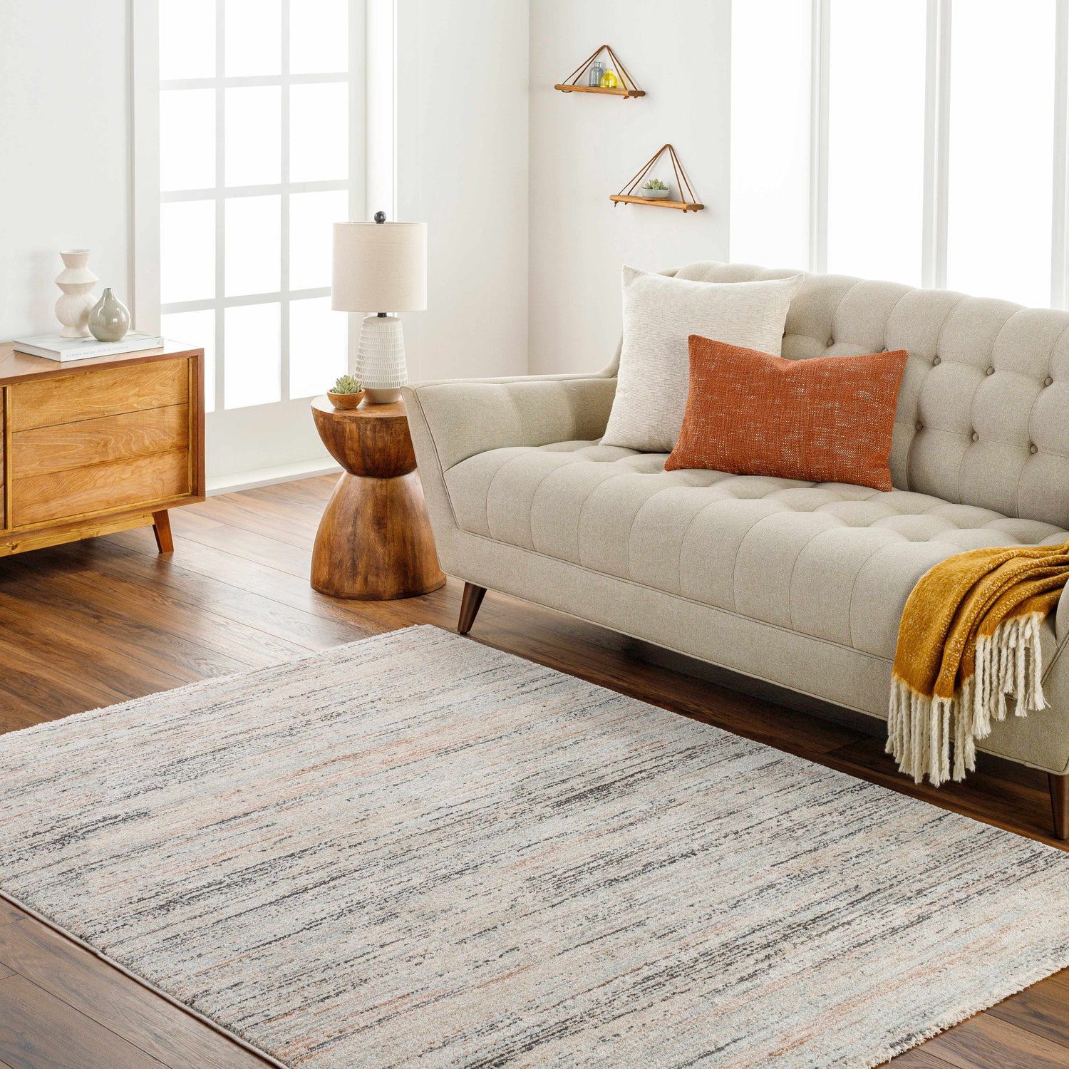 Living room scene with a beige sofa and the Fizza Area Rug in beige, bone, and gray. Roomscene-Rectangle