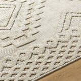 Close-up of Arwid Bone Area Rug showing beige geometric pattern and textured weave on wood floor. Texture