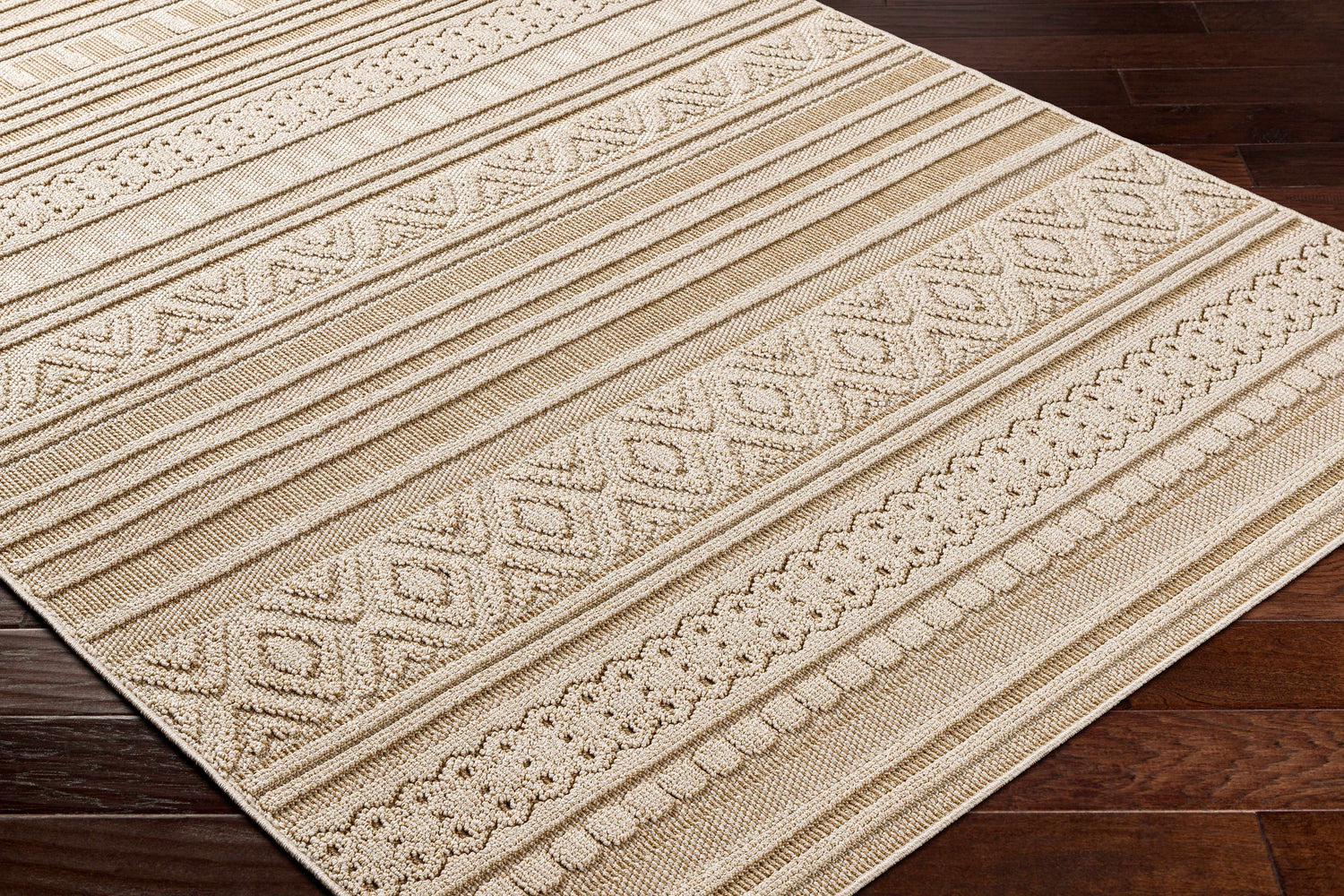 Close-up of the Kojo Lambswool Area Rug showing its camel color, geometric patterns, and textured, machine-woven construction. Corner