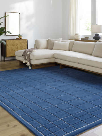 Living room scene with a Sedna Navy Wool Area Rug, cream sectional sofa, and modern wood cabinet. Roomscene-Rectangle