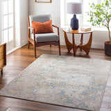 Living room scene with Bella Area Rug in faded driftwood, gray chair, and wood accents. Roomscene-Rectangle