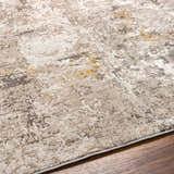 Close-up of the Yuji Area Rug showing its beige, gray, and nutmeg abstract pattern and soft texture. Texture