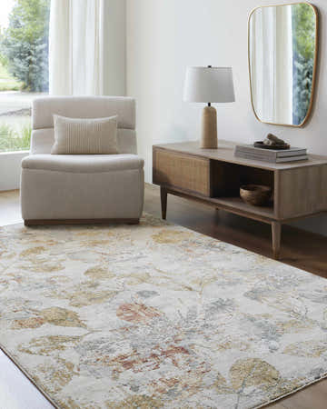 Living room scene with a neutral chair and the Ouida Floral Rug in copper, silver, and natural tones. Roomscene-Rectangle