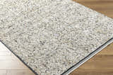 Close-up of the Haran Cloud Gray Area Rug showing its textured, neutral-toned design on hardwood flooring. Corner
