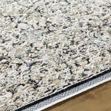 Close-up of Haran Cloud Gray Area Rug showing its farmhouse pattern, cloud gray, black, and tan colors. Texture