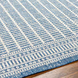 Close-up of the Amena Blue Area Rug showing its geometric pattern and blue and ivory color palette. Texture