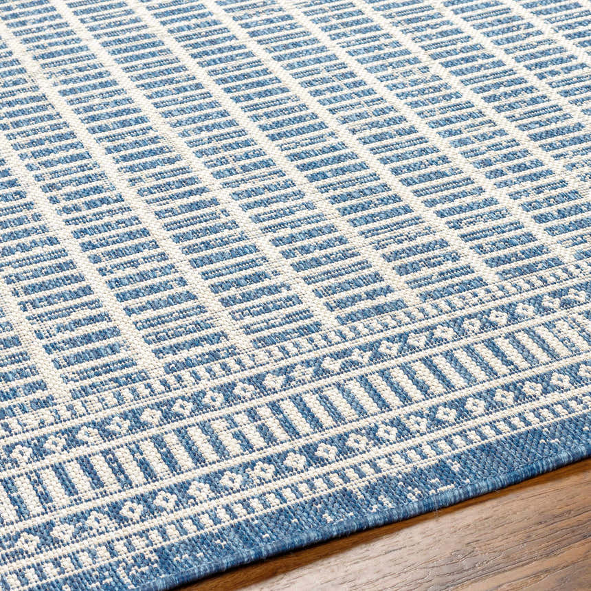 Close-up of the Amena Blue Area Rug showing its geometric pattern and blue and ivory color palette. Texture