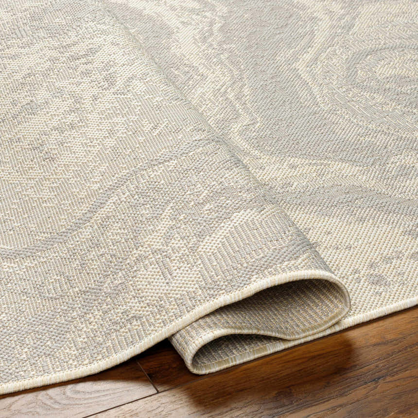 Close-up of the Basma Cream Marble Area Rug showing beige and gray tones and subtle marble pattern. Fold