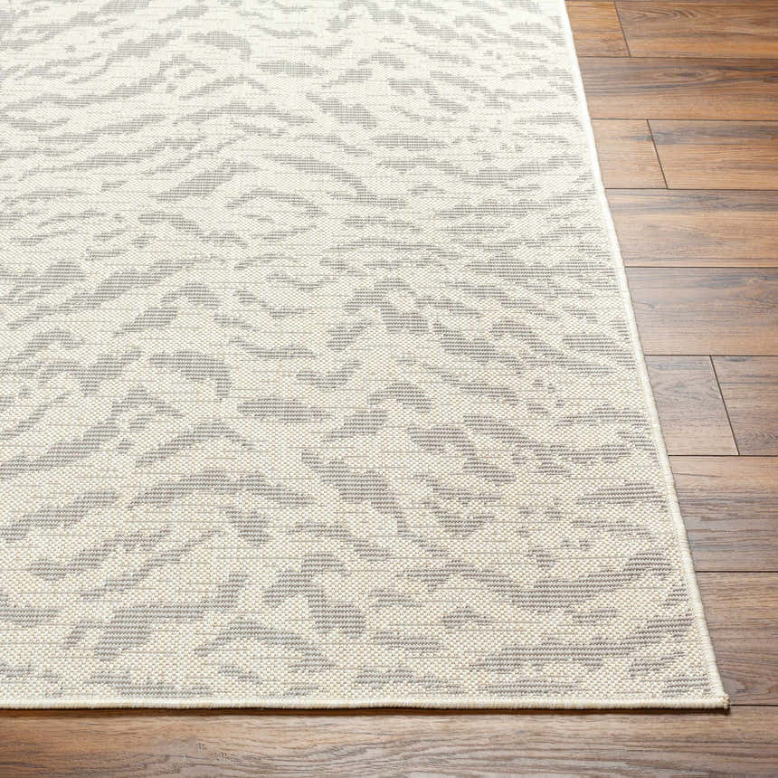Close-up of Friso Cream Area Rug showing beige and gray contemporary pattern and woven texture on wood floor. Front