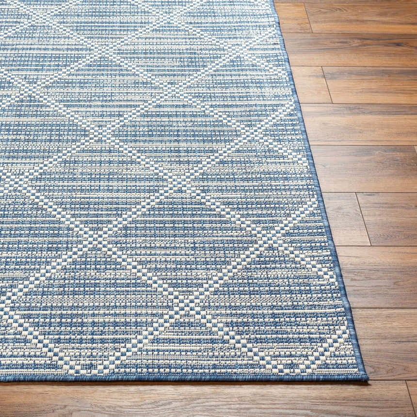 Close-up of the Ivora Blue Area Rug showing its contemporary geometric pattern and texture on hardwood flooring. Front