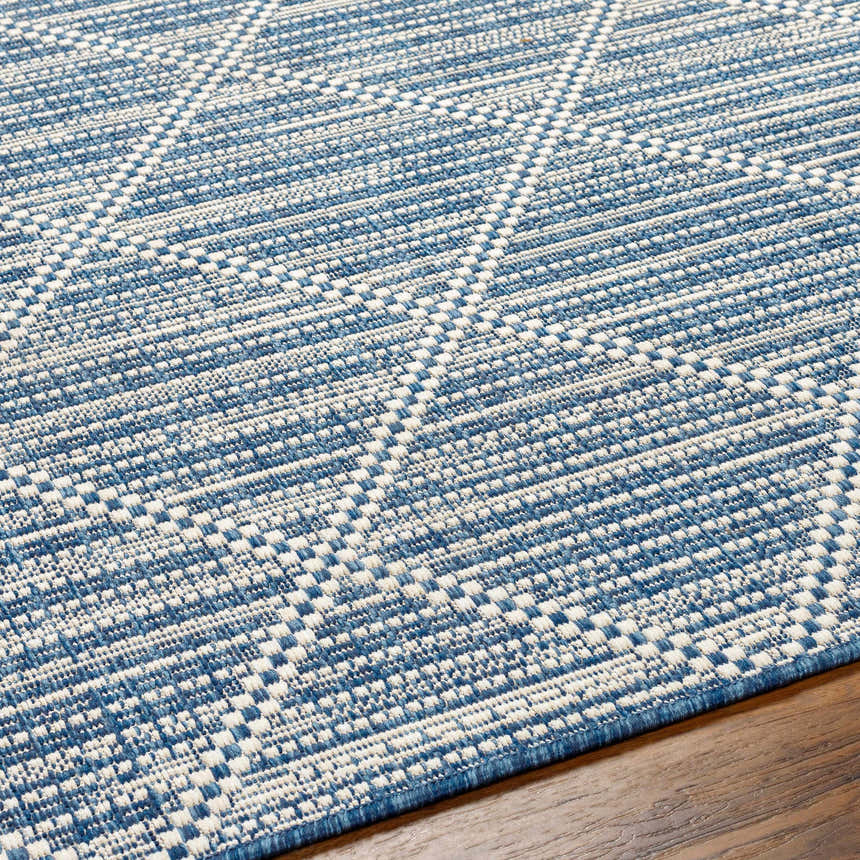 Close up of the Ivora Blue Area Rug showing its textured, woven, geometric pattern in denim and white. Texture